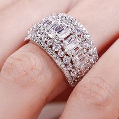 a woman's hand with a diamond ring on top of her finger and an engagement band in the middle