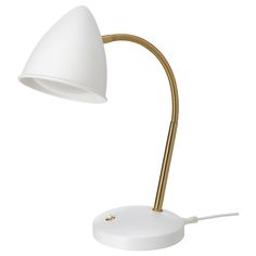 a white desk lamp with a gold metal arm and an electric cord plugged into the base