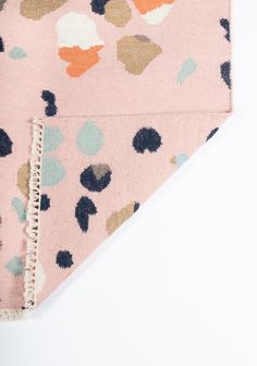 the pink and blue polka dot dog bandana is folded on top of a white surface