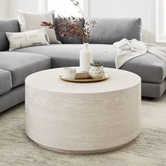 a living room with grey couches and a white coffee table