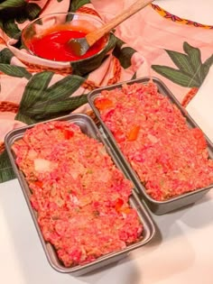 two pans filled with food sitting on top of a table next to a bowl