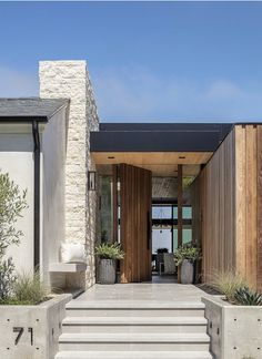 the entrance to a modern home with stone steps