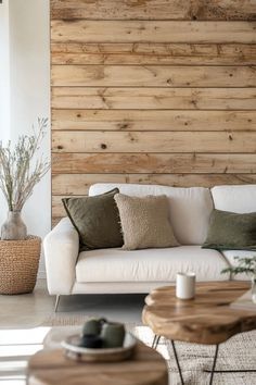 a living room with wood paneling and white couches, coffee table and plant in the corner