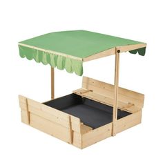 a wooden play set with a green canopy and two drawers underneath it, on a white background