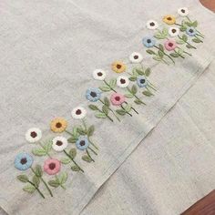 a close up of a table cloth with flowers embroidered on the front and back side