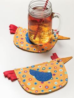 two placemats with birds on them and a mason jar filled with tea in it