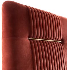 an upholstered red velvet headboard with gold hardware and pleated lines on it