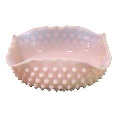 a pink bowl with white polka dots on the rim and bottom, sitting in front of a white background