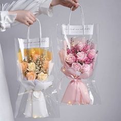 two clear bags with flowers in them being held by someone's hand and another bag is holding the same bouquet