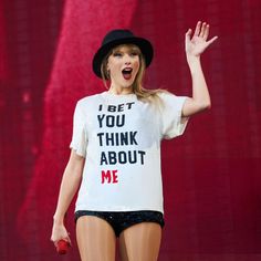 taylor swift performing on stage with her hands in the air while wearing a t - shirt that says, i bet you think about me