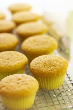 several yellow cupcakes cooling on a wire rack