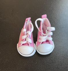 a pair of pink and white shoes sitting on top of a table