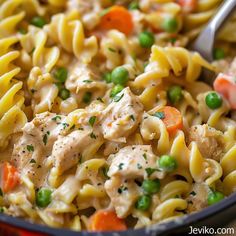 a bowl filled with pasta, peas and chicken