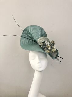 "Sea Green Hat with Quills and Dark Green/Gold Butterfly, perfect for Royal Ascot, Kentucky Derby, Weddings or any special occasion.   A 5mm metal satin covered headband is attached and a comb to secure the hat in place.  Please choose your preference and colour in the \"Variations\" options. These are all handmade by myself so each piece is unique and a one off.  I am an Irish Designer living just outside London.  1-4 days to prepare hat to your requirements. FREE shipping to UK MAINLAND for a limited time only.   Please feel free to ask any questions or if you have a special requirement, I am happy to assist." Butterfly Hat, Hat Fascinator, Designer Living, Green Hat, Mother Of Bride, Green Butterfly, Green Hats, Royal Ascot, Gold Butterfly