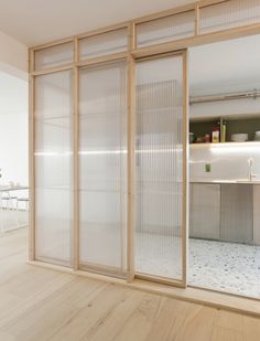 an empty room with sliding glass doors leading into the kitchen