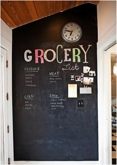 a blackboard with the words grocery written on it and a clock mounted to the wall