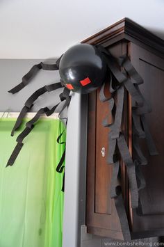 a spider balloon hanging from the side of a cabinet