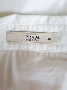 Info:- 🔅 Brand : PRADA 🌷 Size : 46 🍊 MADE IN ITALY 🍇 72% Cotton, 23% Nylon, 5% Elastane Fabric 🍓 In excellent condition Measurement: 🍎 Bust : 38 inches 🎀 Shoulder : 16 inches 🍉 Sleeve : 19 inches. 🍀 Waist : 30-34 inches 🥦 Length : 23 inches. Shipping: US$ 15 Shipment: All items are shipped to you registered International Airmail. Payment: We accept payment through Paypal. Thank you for looking Designer Cotton Button-up Blouse, Designer Cotton Tops For Office, Vintage Print Blouse, Bow Tie Shirt, Tsumori Chisato, Tie Shirt, Elastane Fabric, Beautiful Blouses, White Blouse