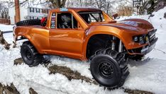 an orange truck is parked in the snow