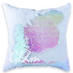 a white pillow with pink and blue sequins on the front, featuring an image of a woman's face