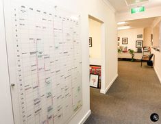 a large white board in an office with calendars on the wall next to it