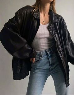 a woman in black jacket and jeans posing for the camera