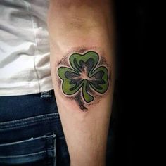 a man's arm with a shamrock tattoo on it