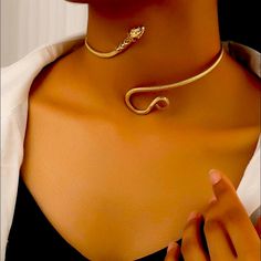 a woman wearing a gold necklace with a snake on it