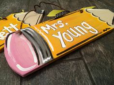 two yellow and pink wooden signs that say, let's mrs young on them