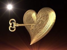 a golden heart shaped key hanging from the side of a wall with a light shining on it