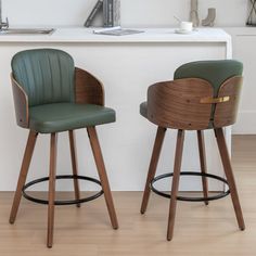 two green leather bar stools in front of a white counter with a clock on it