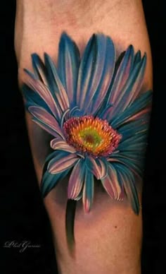 a colorful flower tattoo on the leg