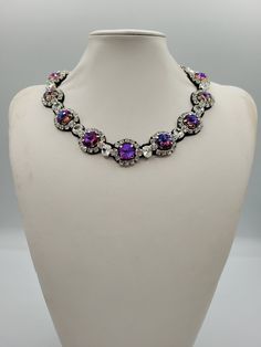 Each piece of our statement necklaces is handmade and one of a kind made in Italy. Our creations is made of high quality materials such as crystals and rhinestones. Each embroidered material is carefully hand sewn. Very glamorous and stylish. Perfect gift to someone you like. Materials Strass stones in Crystal and Violet blue color in different shape and dimension.  Black eco leather backing. Aluminium color hook closure. Measurements Weight approximate 150 grams. Circumference approximate 59 cm - 23,22 in Feel free to contact us if you have any question. Thank you so much for looking at our shop and our articles each of them, single piece. Party Crystal Pendant Necklace With Rhinestones, Adjustable Pendant Crystal Necklace For Party, Adjustable Crystal Pendant Necklace For Parties, Adjustable Jeweled Crystal Necklaces, Unique Crystal Jewelry With Rhinestones, Evening Rhinestone Pendant Necklace, Elegant Purple Necklace For Party, Purple Jeweled Necklace For Party, Rhinestone Pendant Necklace With Sparkling Stones For Party