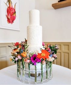 there is a white cake with flowers in the middle on top of a round table