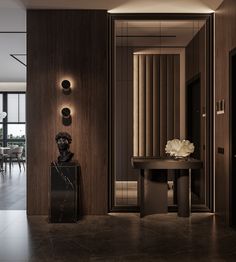 an elegant entry way with marble and wood accents, along with a black vase filled with white flowers