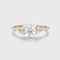 a yellow gold engagement ring with an oval cut diamond surrounded by small round brilliant diamonds