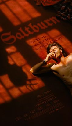 a man laying on the ground in front of a window talking on a cell phone