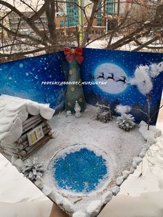 a person holding up a paper cut out of a snow scene