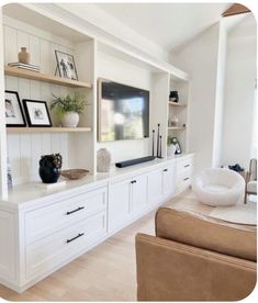 a living room filled with furniture and a flat screen tv on top of a wooden shelf