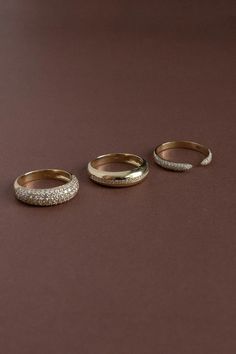 three gold wedding bands with diamonds on them