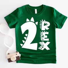 a green t - shirt with the number two on it next to a pair of sunglasses