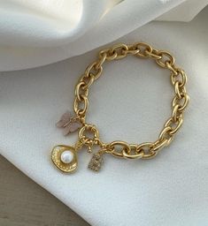 Adorn your wrist with this stunning gold-plated bracelet featuring a sailor lock and oyster pearl charm. This special design combines nautical elegance with luxurious gold plating, making it a standout piece for any jewelry collection. ⚓ Gold-plated sailor lock charm for a nautical-inspired, chic look 🌊 Oyster charm with a beautiful pearl for added elegance Crafted with durable high-quality gold plating for long-lasting wear Perfect for both casual and formal occasions, adding a unique touch to any outfit A great gift for lovers of nautical and nature-inspired jewelry Bracelets Design, Oyster Pearl, Design Bracelet, Nautical Jewelry, Nature Inspired Jewelry, Gold Plated Bracelets, Pearl Charms, Special Design, Charm Bracelets