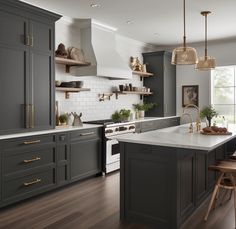 a large kitchen with gray cabinets and white counter tops, wood flooring and wooden stools