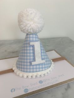 A handmade mini party hat made of baby blue and white cotton felt backed gingham fabric, white wool pompom and white mini pompom trim finished with blue and white age of your choice. Perfect for birthday celebrations, photo shoots, cake smash. A matching badge is also available on another listing. Mini party hat measures 10cm high x 7cm at the base. Please note they are all made by hand so measurements may vary. The hat is made on a super soft nylon band. All items are made to order, so if there Gingham Party, Dog Birthday Hat, 1st Birthday Hats, First Birthday Hats, Hat Cake, 1st Birthday Party Decorations, Gingham Fashion, Birthday Photo Props, Party Headband