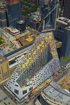 an aerial view of a large building under construction in the middle of a big city