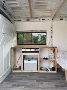 the inside of a camper with a bed and desk