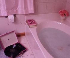 a pink bathroom with a record player and bathtub