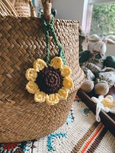 a sunflower is hanging from the handle of a woven basket on a rug with other items in the background