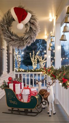 a christmas porch decorated for the holiday season with presents and reindeer sleighs