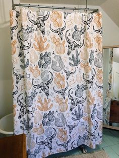 a bathroom with a shower curtain that has various designs on it